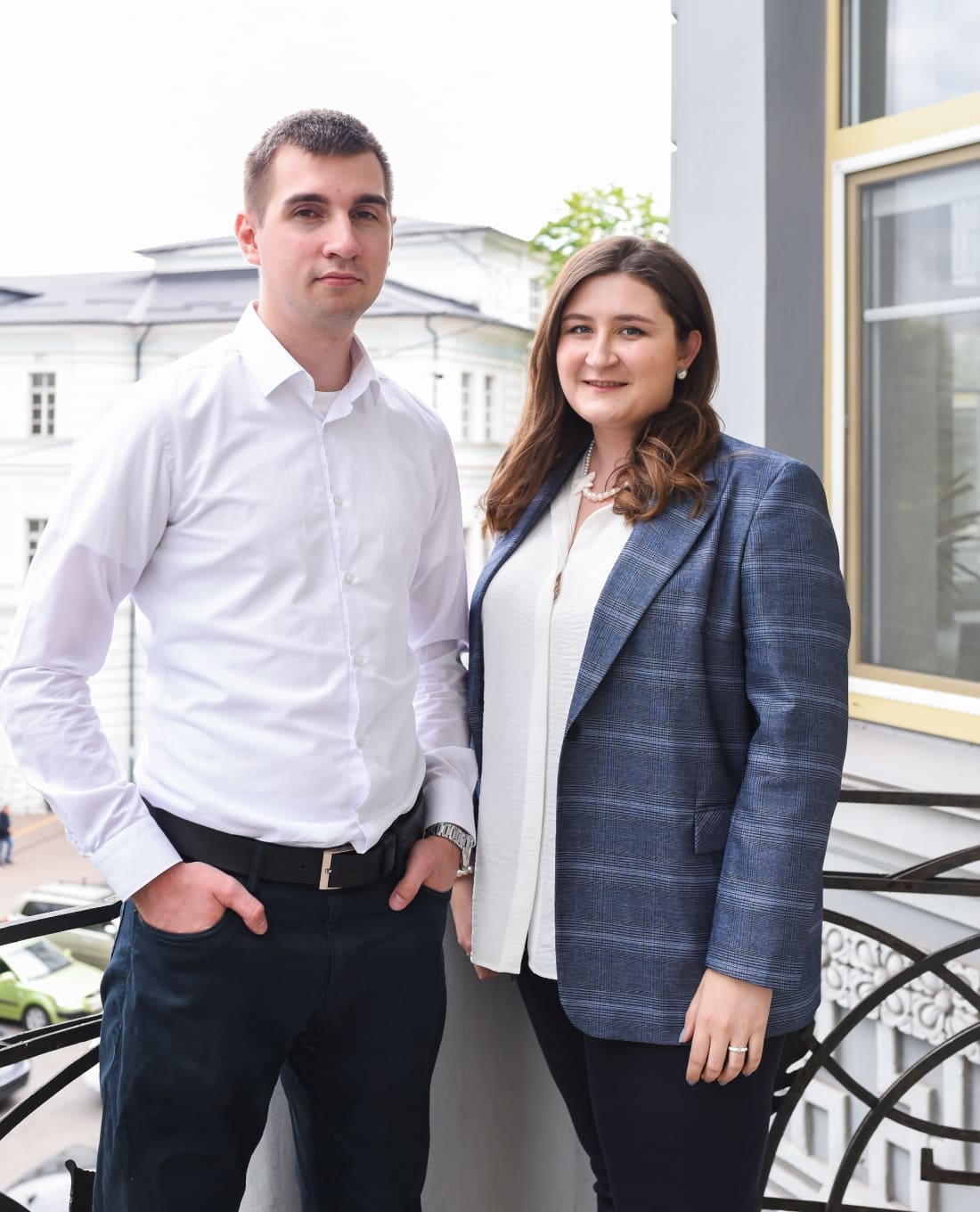 Research consultants at Kyiv Consulting posing outdoors on a balcony of their office in Kontraktova Square.